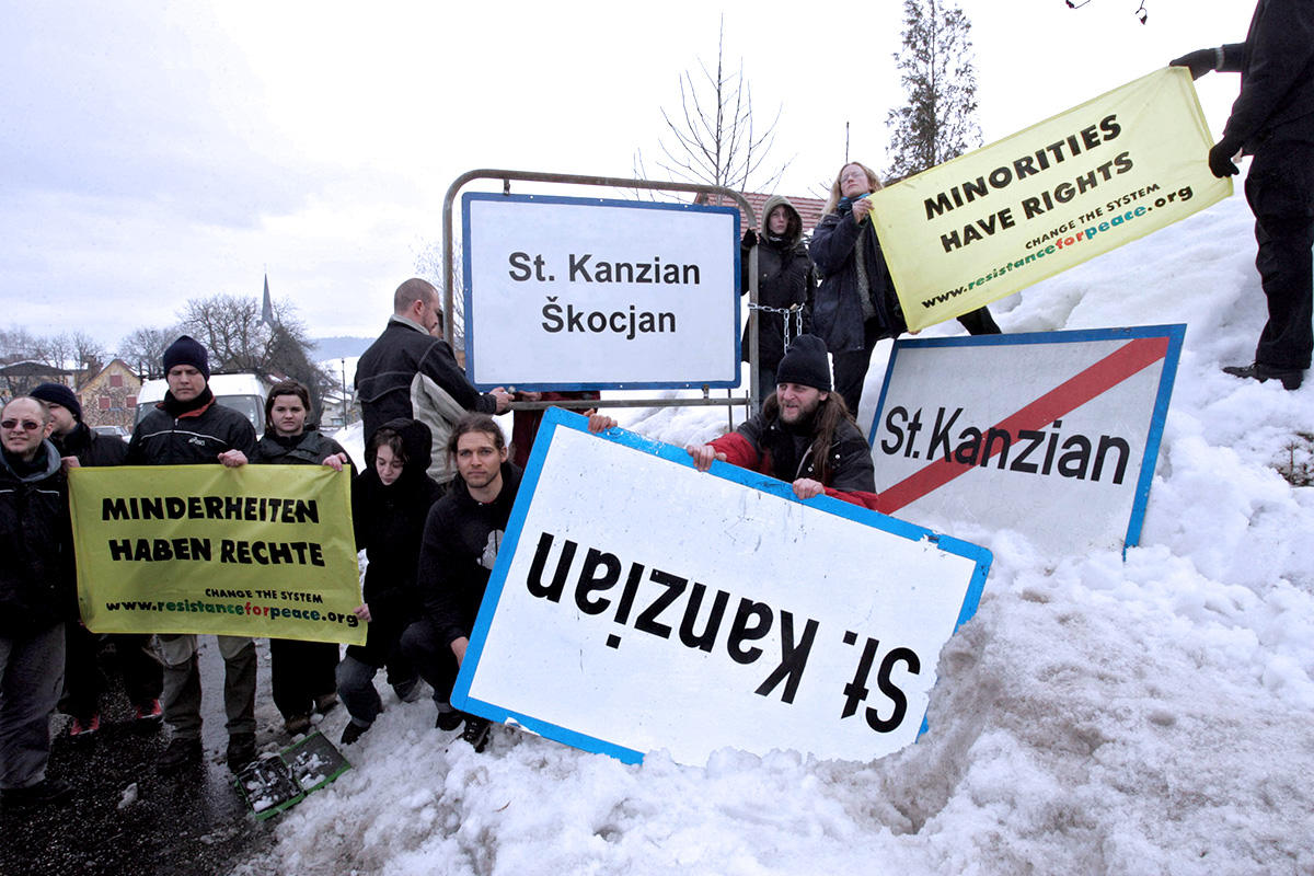 Des manifestants se sont enchaînés au panneau bilingue de leur village, Sankt Kanzian, en février 2006, clamant que 'les minorités ont des droits'.